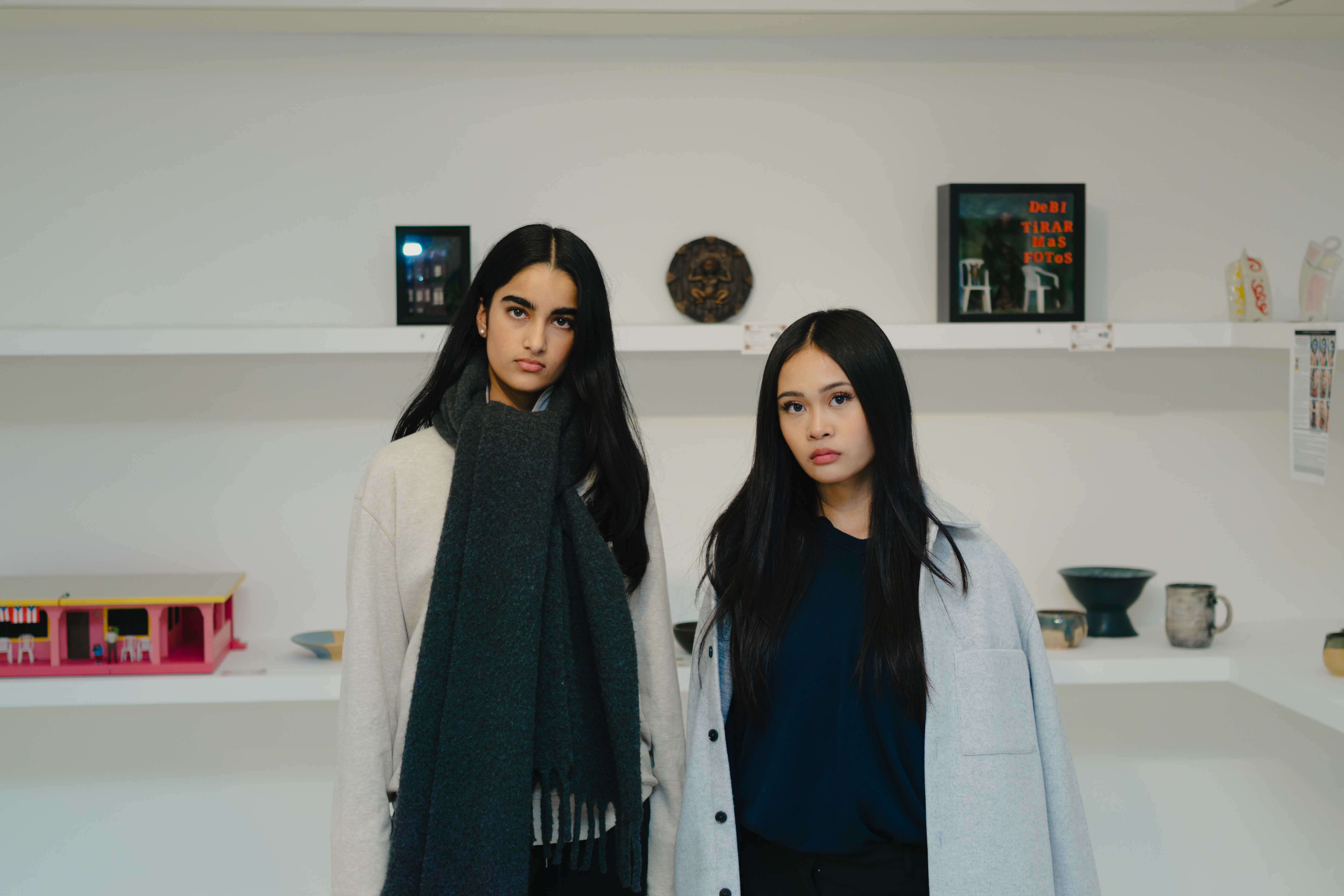 Two women standing in front of art display